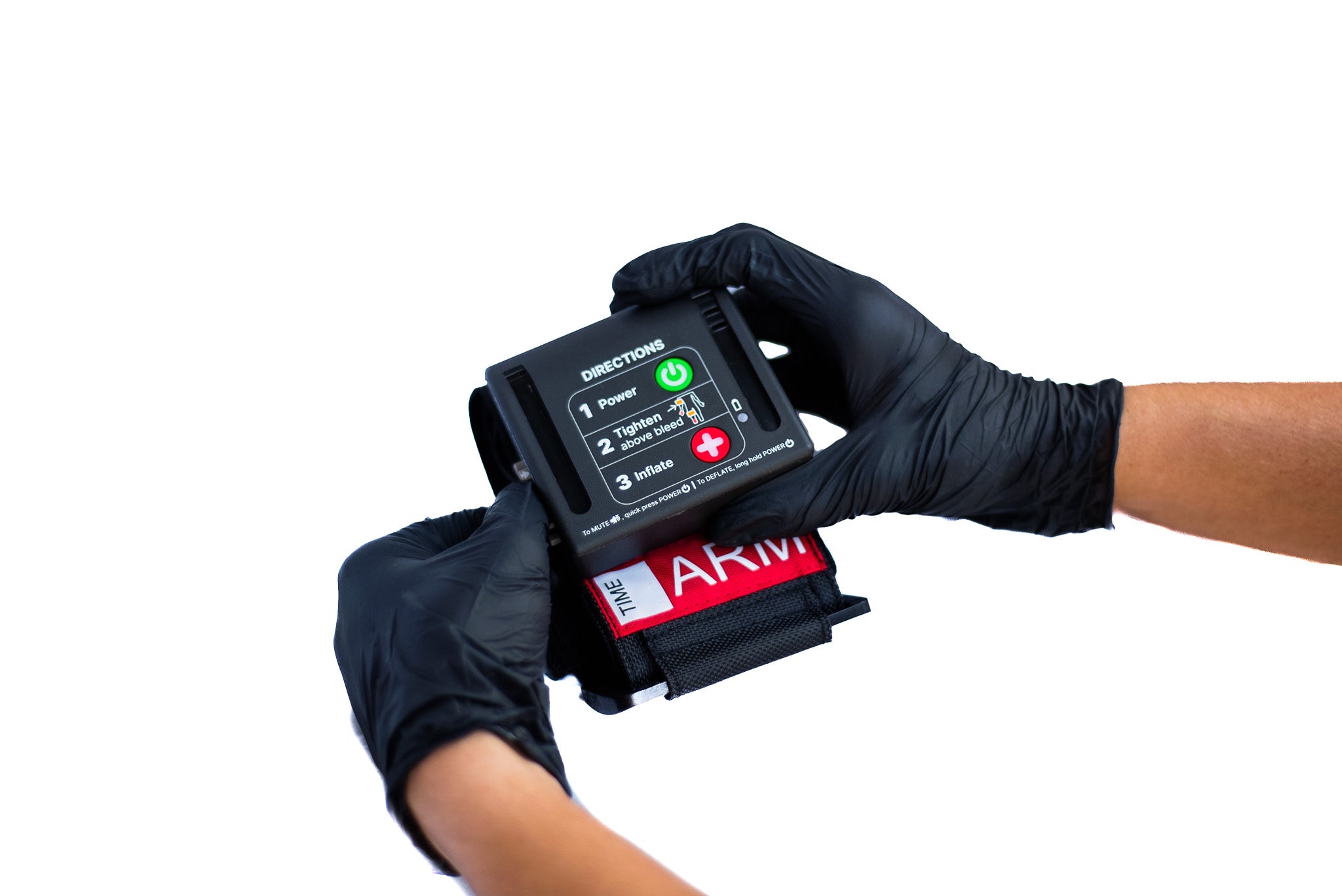 Hand wearing a black glove holding a AutoTQ (automated tourniquet) device on a white background