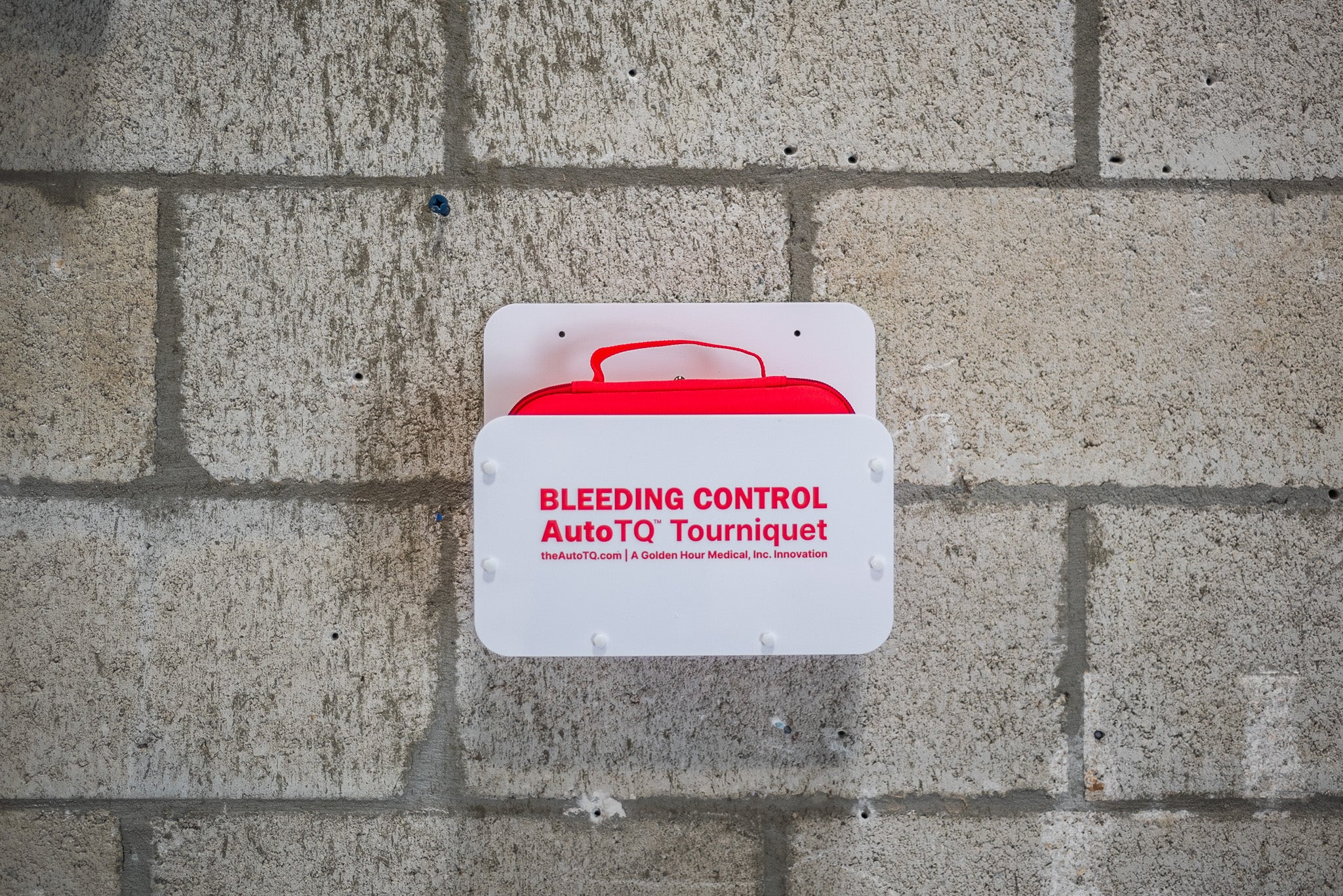 Bleeding control AutoTQ Tourniquet on a concrete wall