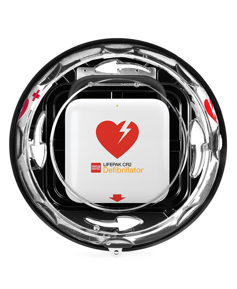 Top-down view of a LIFEPAK CR2 Defibrillator inside a circular metallic mounting frame, featuring a white central unit with a red heart and lightning bolt logo.