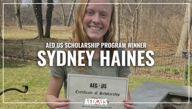 Sydney Haines poses in back yard with AED.US scholarship certificate.