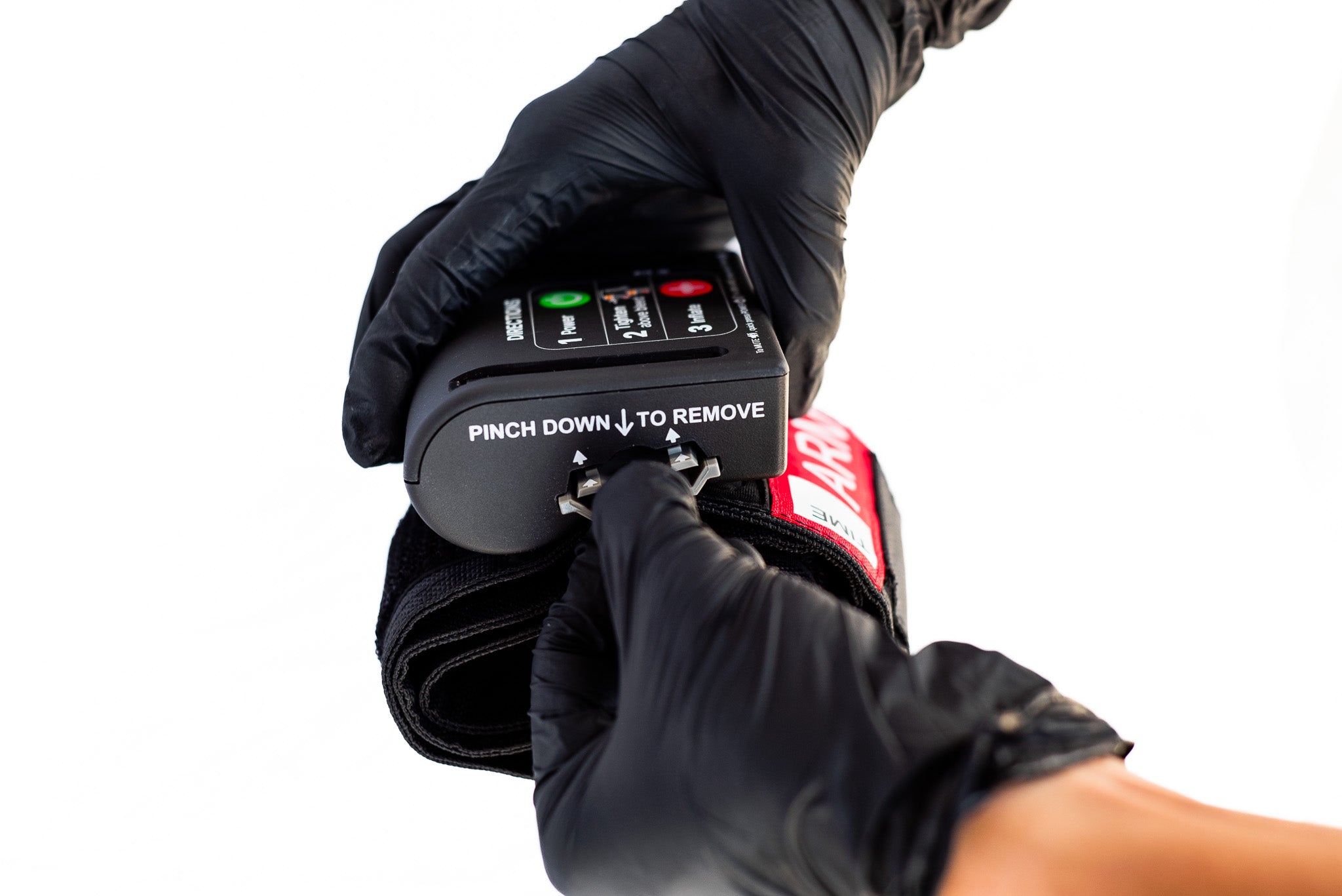 Person wearing black gloves using an AutoTQ device with a control panel on a white background